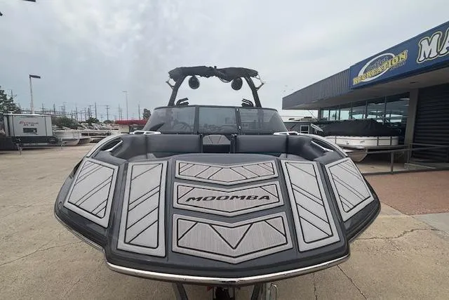 Slide: The Image of 2022 Moomba Kaiyen boat with sleek design, parked outside dealership. - 6