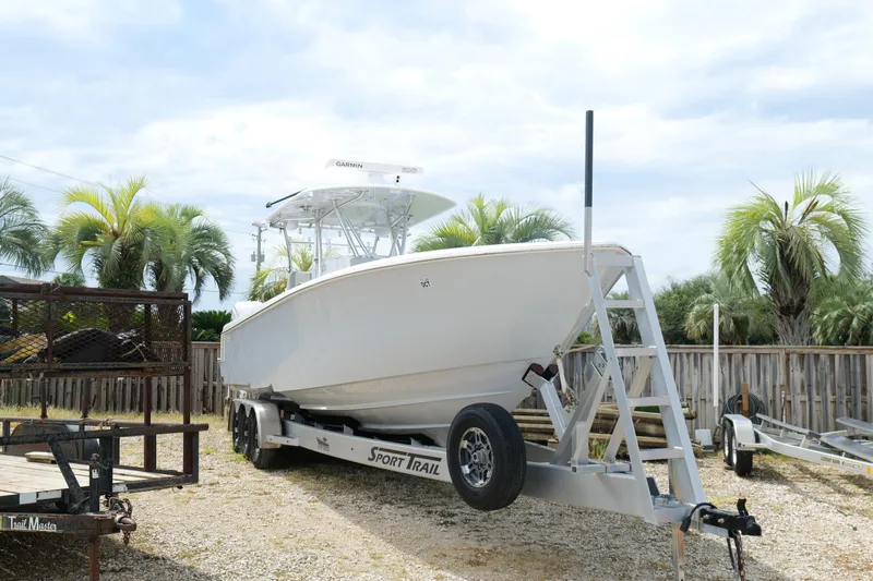 Slide: The Image of 2024 Contender 35 ST boat on trailer, surrounded by palm trees. - 1
