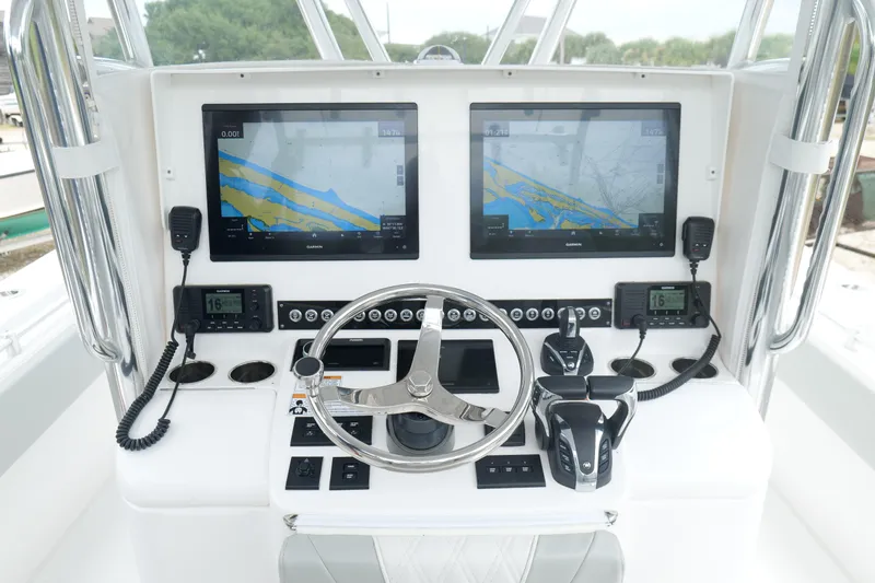 Slide: The Image of 2024 Contender 35 ST boat dashboard with dual Garmin displays and steering wheel. - 18