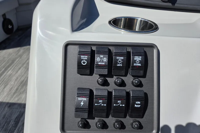 Slide: The Image of Control panel of 2026 Bentley Pontoons LE 180 Cruise with various switches and cup holder. - 11