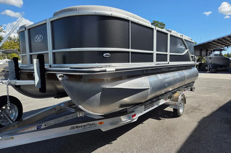 Slide: The Image of 2026 Bentley Pontoons LE 180 Cruise on trailer, parked outdoors under clear blue sky. - 4