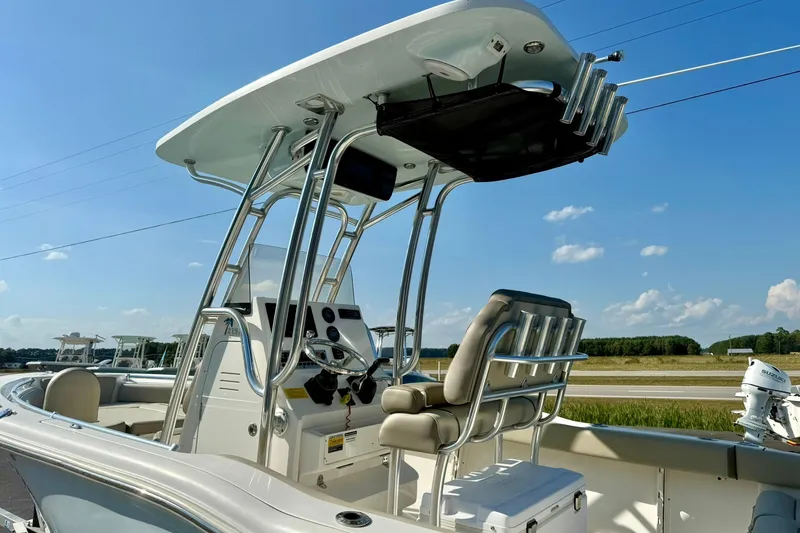 Slide: The Image of 2022 Key West 219 FS boat with T-top and helm station under clear blue sky. - 10