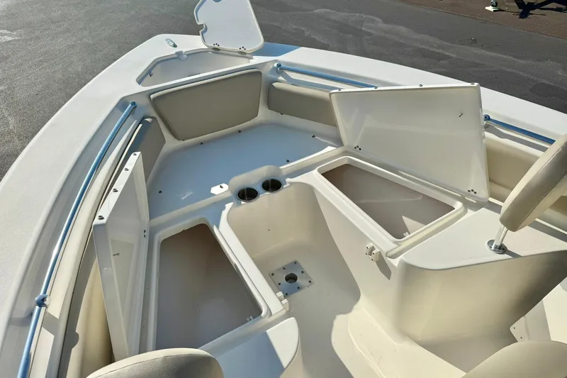 Slide: The Image of 2022 Key West 219 FS boat interior with open storage compartments and cup holders. - 18