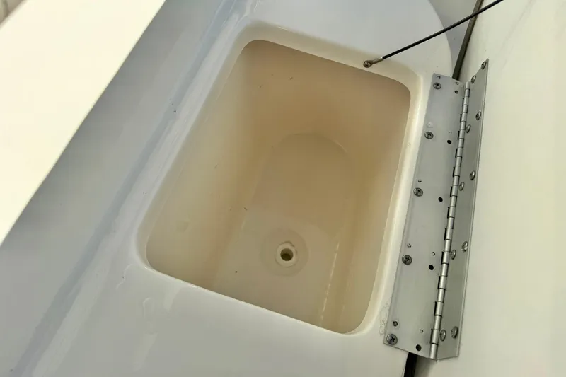Slide: The Image of 2022 Key West 219 FS boat storage compartment with open lid and hinge detail. - 22