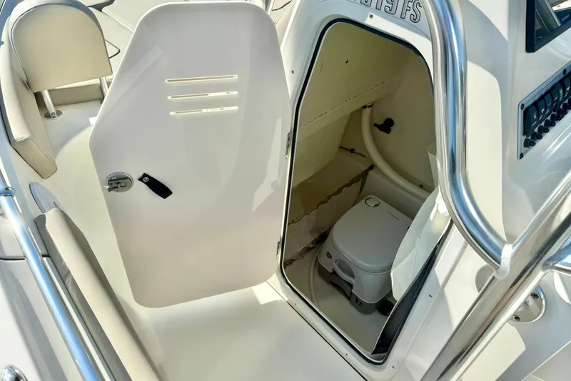 Slide: The Image of 2022 Key West 219 FS boat interior with compact toilet and storage area. - 27