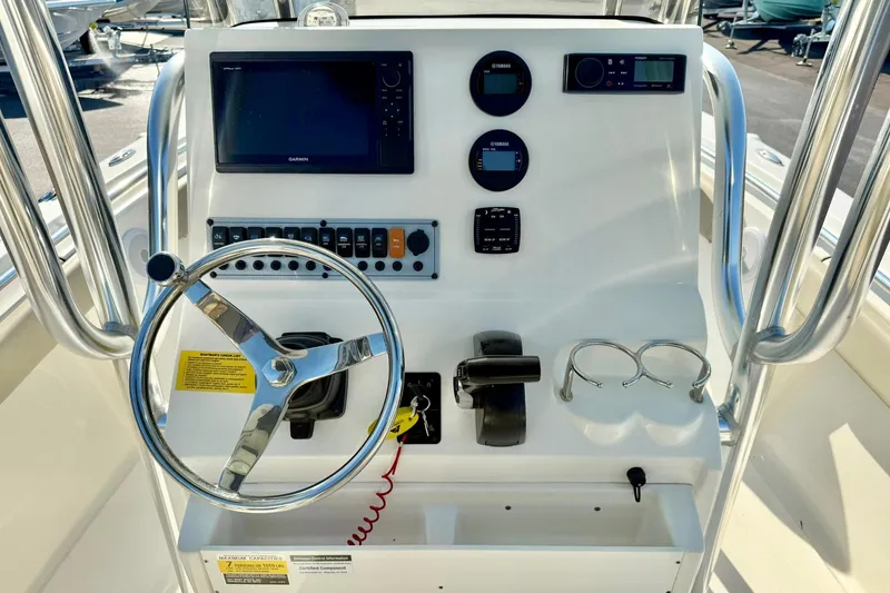 Slide: The Image of 2022 Key West 219 FS boat console with steering wheel, controls, and navigation display. - 3