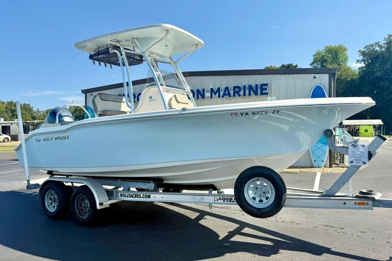 Slide: The Image of 2022 Key West 219 FS boat on trailer at dealership, sunny day. - 4