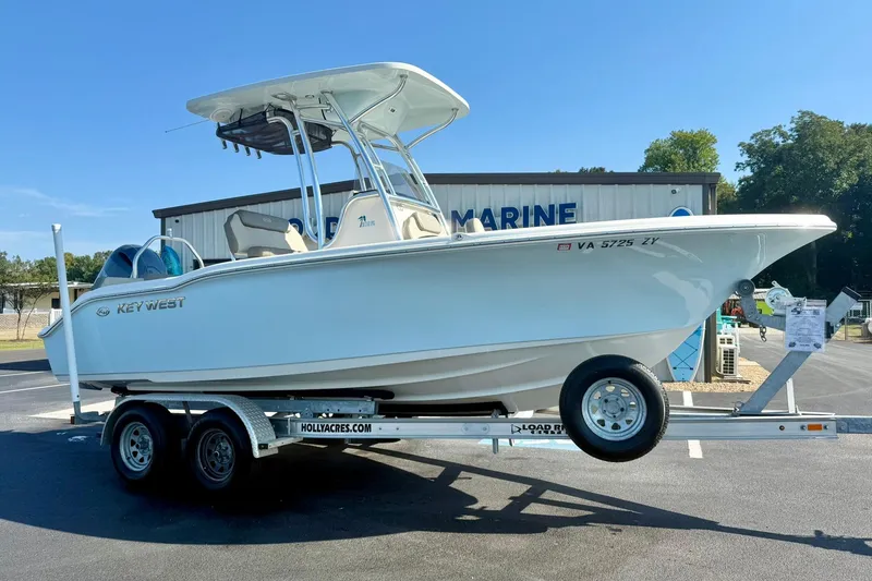 Slide: The Image of 2022 Key West 219 FS boat on trailer, parked outside marine dealership. - 6