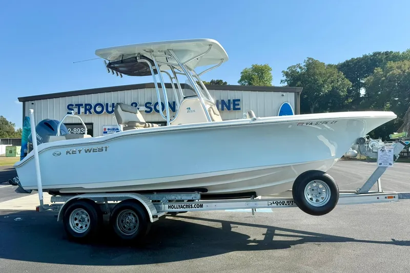Slide: The Image of 2022 Key West 219 FS boat on trailer outside dealership, sunny day. - 7