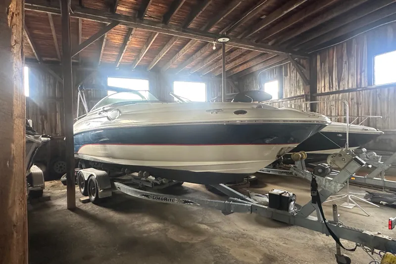 Slide: The Image of 2002 Sea Ray 240 Sundeck boat on trailer in wooden storage shed. - 6
