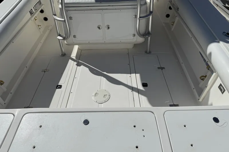 Slide: The Image of 2001 Marlago 35 Cuddy boat deck, featuring storage compartments and stainless steel railings. - 19