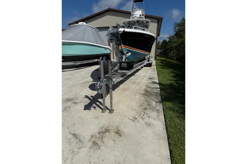 Slide: The Image of 2001 Marlago 35 Cuddy boat on trailer, parked outdoors near a building. - 24