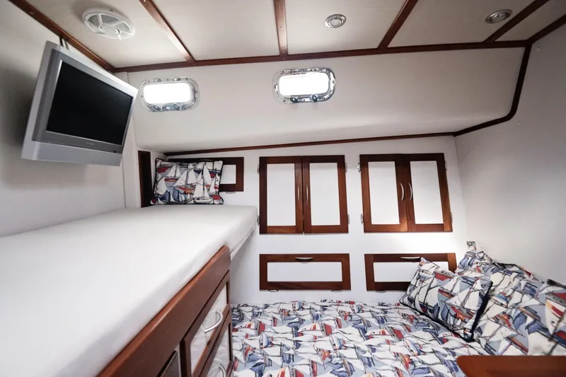 Slide: The Image of 2007 Pilot Cruiser Expedition cabin with nautical-themed bedding and wall-mounted TV. - 39