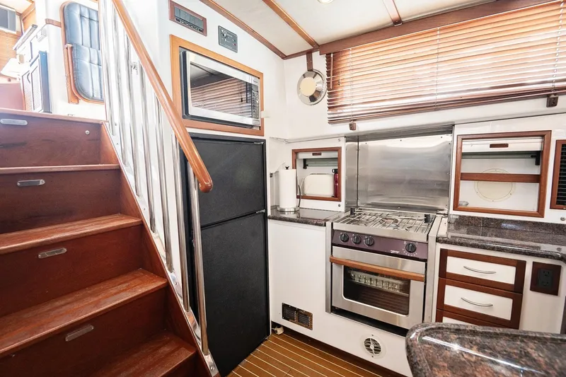 Slide: The Image of 2007 Pilot Cruiser Expedition yacht kitchen with wooden stairs, modern appliances, and sleek cabinetry. - 49