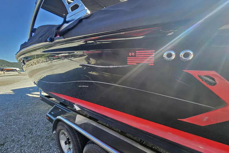 Slide: The Image of 2006 MasterCraft X-80 boat with sleek black and red design on a trailer. - 12