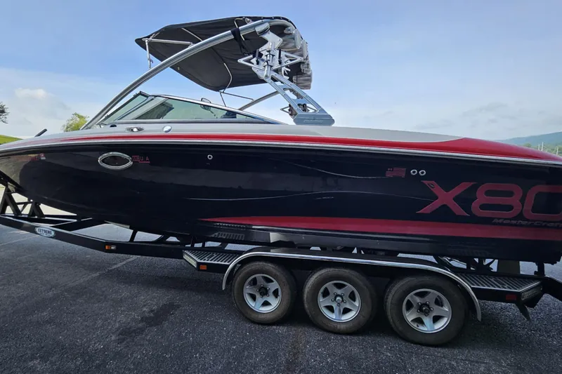 Slide: The Image of 2006 MasterCraft X-80 boat on trailer, black and red design, parked outdoors. - 3