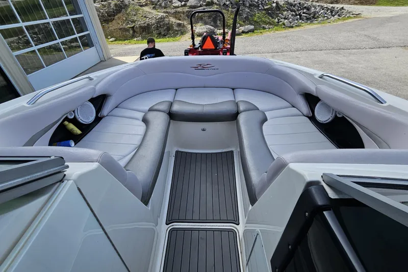 Slide: The Image of 2006 MasterCraft X-80 boat interior with gray seating and speakers, parked near a garage. - 4