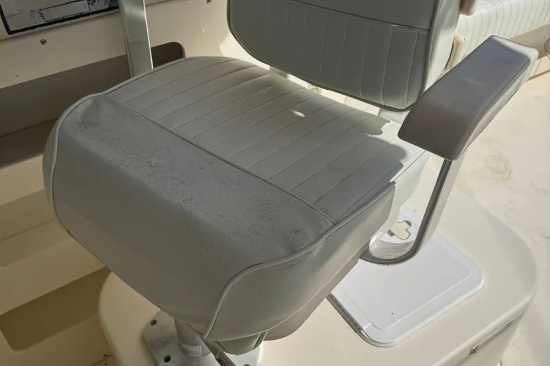 Slide: The Image of Captain's chair on 2008 Parker 2510 XL Walkaround boat, featuring padded armrests. - 16