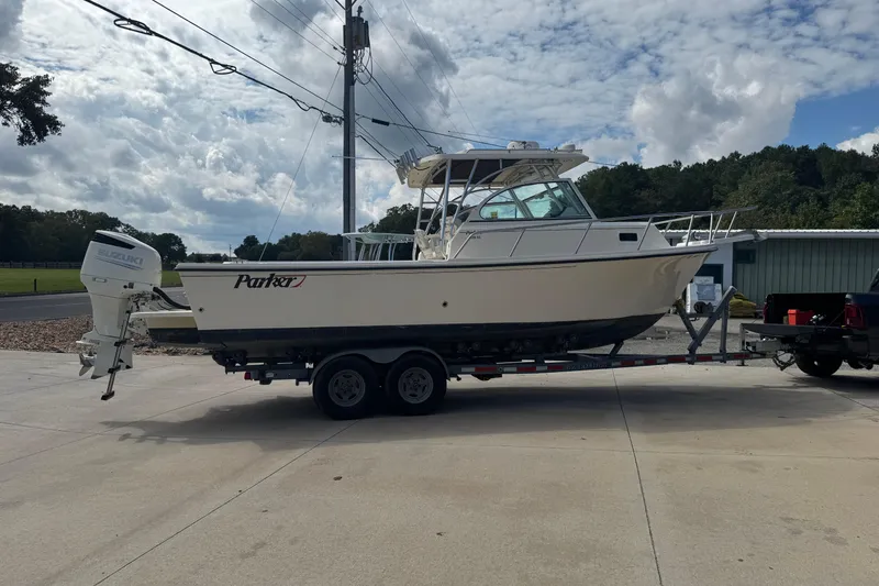 Slide: The Image of 2008 Parker 2510 XL Walkaround boat on trailer, parked outdoors under cloudy sky. - 3