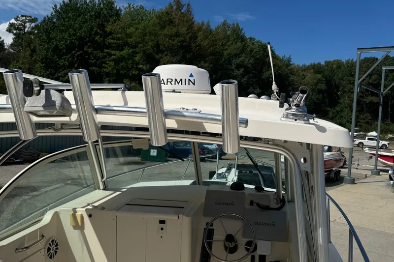 Slide: The Image of 2008 Parker 2510 XL Walkaround boat with Garmin equipment and rod holders, docked outdoors. - 5