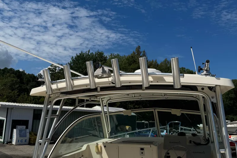 Slide: The Image of 2008 Parker 2510 XL Walkaround boat with rod holders, under a clear blue sky. - 6