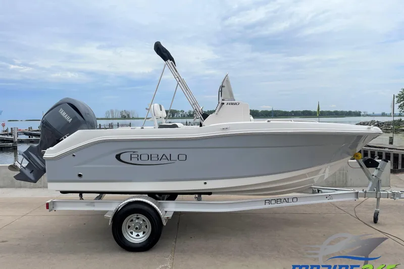 The Image of 2026 Robalo R180 Center Console boat on trailer by waterfront. - 0