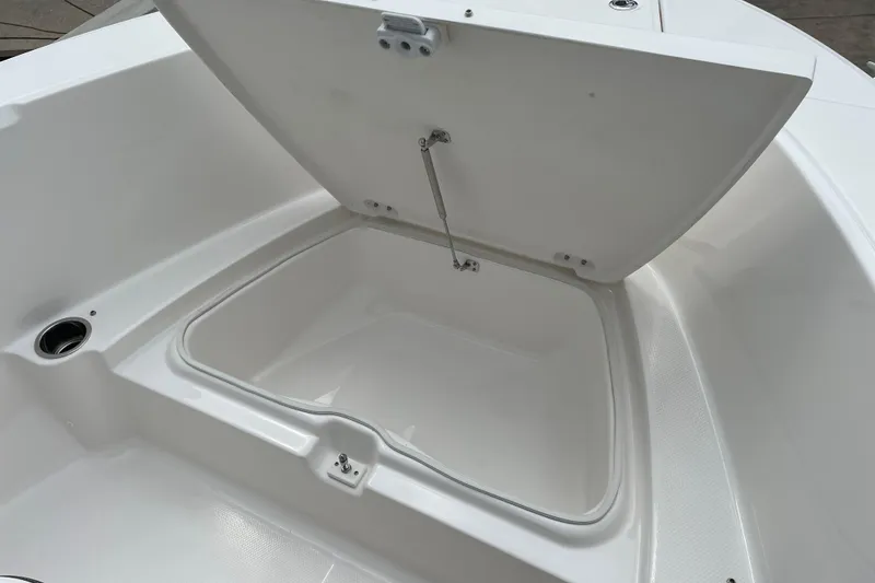 Slide: The Image of 2026 Robalo R180 Center Console storage compartment with open lid, showcasing spacious interior. - 10