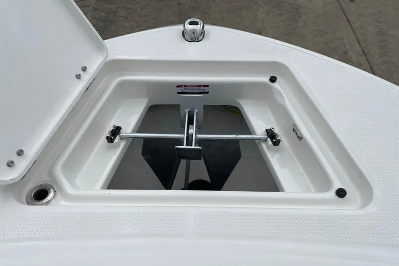 Slide: The Image of 2026 Robalo R180 Center Console anchor storage compartment, open lid, white interior. - 13