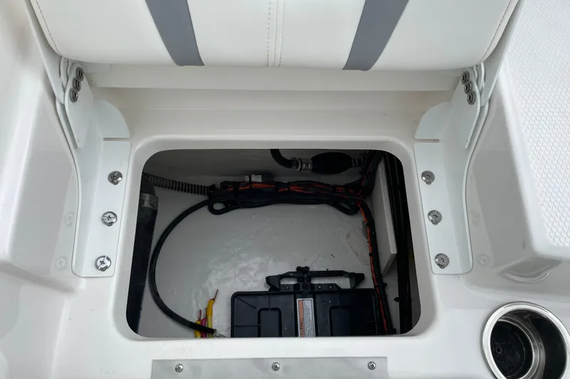 Slide: The Image of 2026 Robalo R180 Center Console storage compartment with wiring and battery setup. - 17