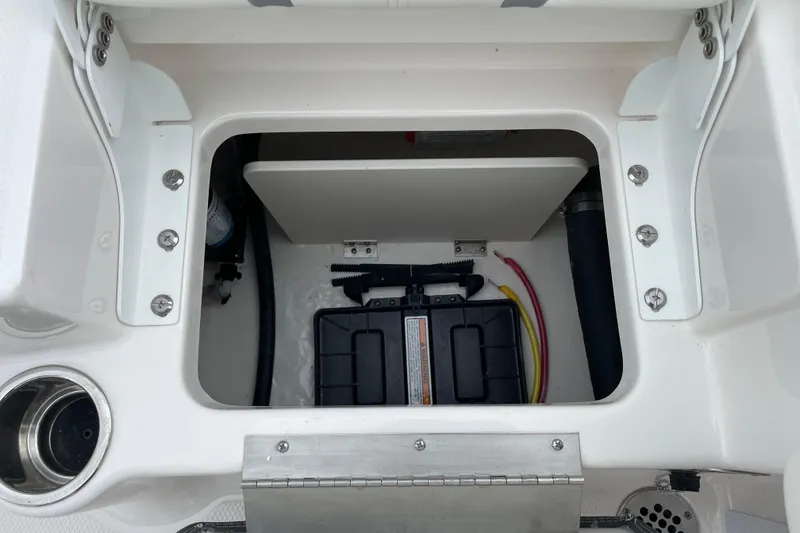 Slide: The Image of 2026 Robalo R180 Center Console battery compartment with wiring and storage space. - 18