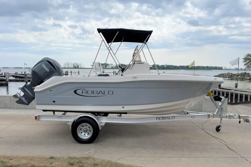 Slide: The Image of 2026 Robalo R180 Center Console boat on trailer by waterfront. - 8