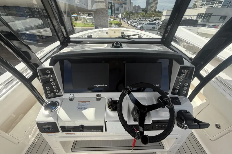 Slide: The Image of 2023 Robalo R302 Center Console helm with Raymarine displays and modern controls. - 7