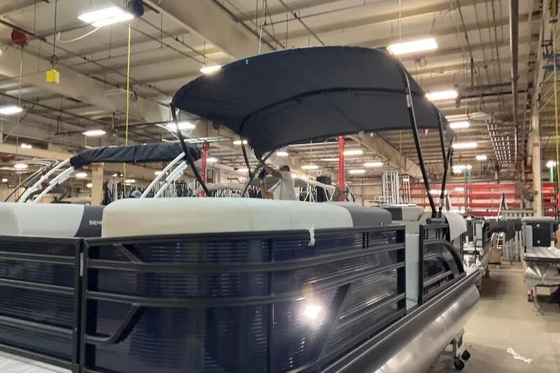 Slide: The Image of 2026 Bennington 22 SSRSF pontoon boat in a garage, featuring sleek design and comfortable seating. - 8