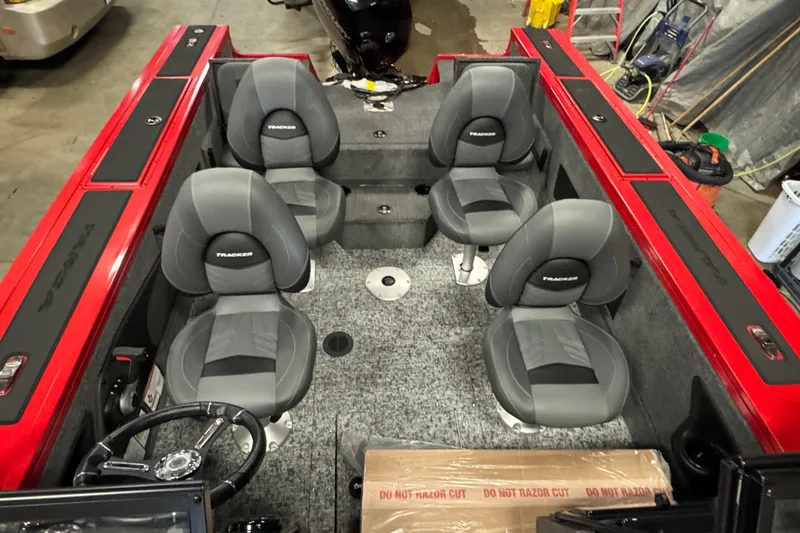 Slide: The Image of 2026 Tracker Targa V-18 Combo boat interior with four gray seats and red accents. - 13