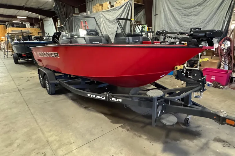 Slide: The Image of 2026 Tracker Targa V-18 Combo boat in a warehouse, red hull on trailer. - 2