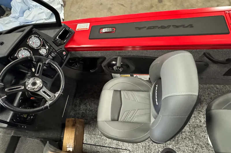 Slide: The Image of 2026 Tracker Targa V-18 Combo boat interior with steering wheel and gray seating. - 6
