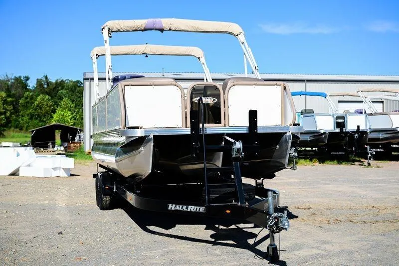 Slide: The Image of 2023 Aloha Pontoon Mahalo 23 on trailer, parked outdoors under clear blue sky. - 4