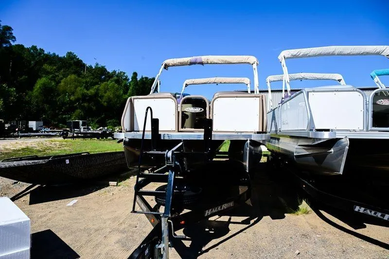 Slide: The Image of 2023 Aloha Pontoon Mahalo 23 boats on trailers in a sunny outdoor setting. - 5