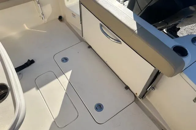 Slide: The Image of 2022 Scout 215 XSF boat interior with storage compartment and seating area. - 11
