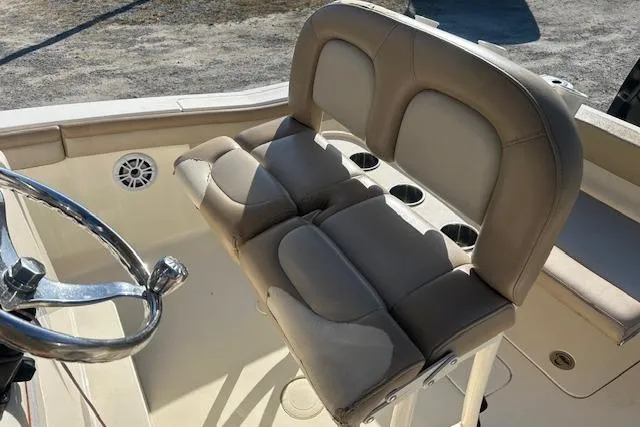 Slide: The Image of 2022 Scout 215 XSF boat helm with cushioned seating and steering wheel. - 13