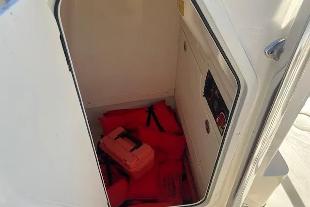 Slide: The Image of Storage compartment in 2022 Scout 215 XSF boat with life jackets and safety equipment. - 14