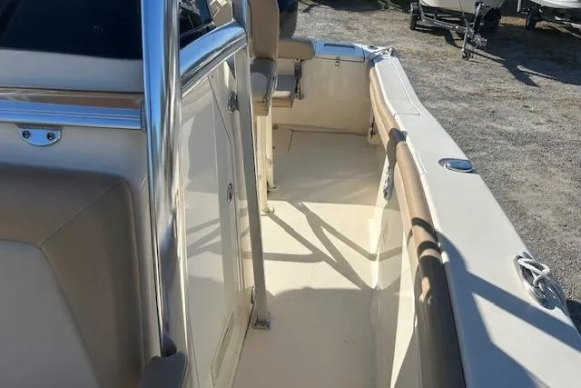 Slide: The Image of 2022 Scout 215 XSF boat interior with beige seating and stainless steel accents. - 16