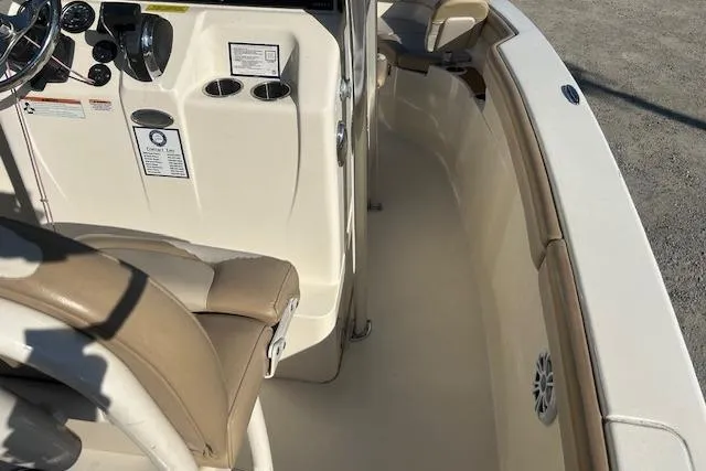 Slide: The Image of 2022 Scout 215 XSF boat interior with beige seating and control panel. - 22