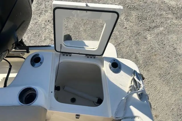 Slide: The Image of 2022 Scout 215 XSF boat with open storage compartment and cup holders. - 24