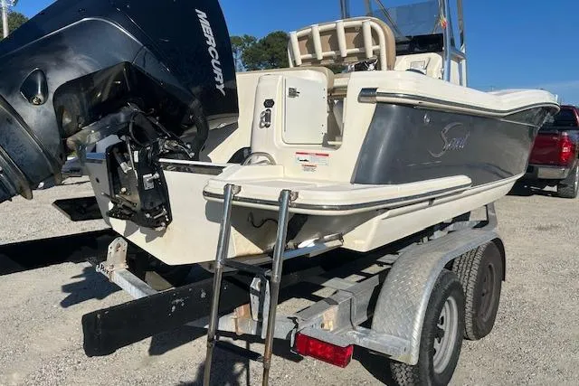 Slide: The Image of 2022 Scout 215 XSF boat on trailer with Mercury engine, parked outdoors. - 5