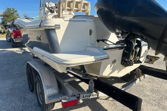 Slide: The Image of 2022 Scout 215 XSF boat on trailer with outboard motor, parked outdoors. - 7