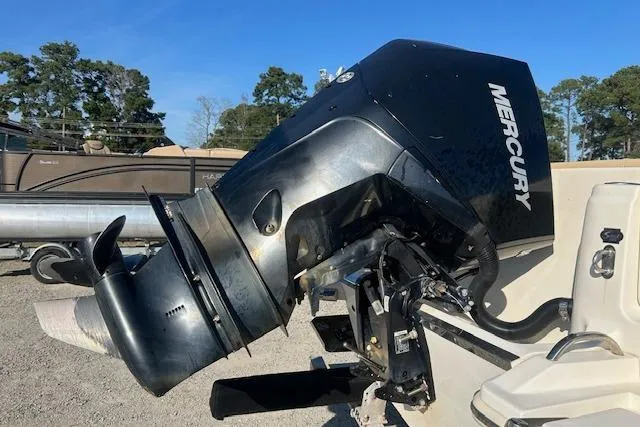 Slide: The Image of 2022 Scout 215 XSF boat with Mercury outboard motor, parked outdoors. - 9