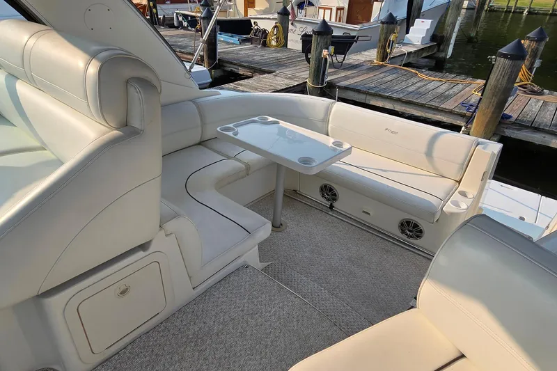 Slide: The Image of 2005 Cruisers Yachts 340 Express interior with white seating and table at dock. - 8
