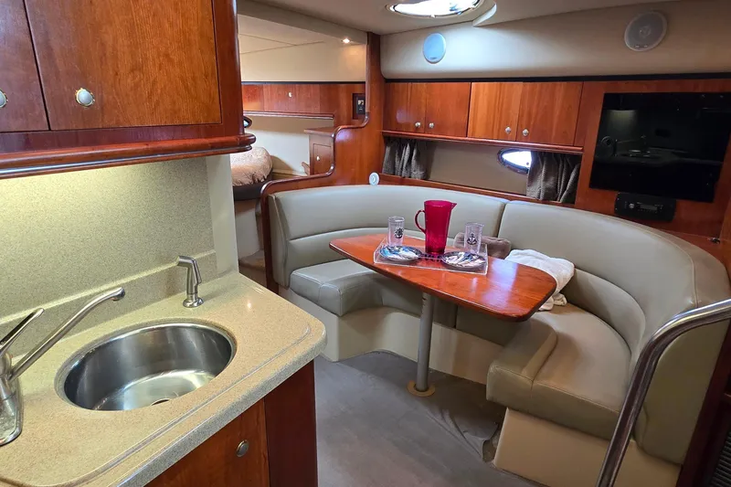 Slide: The Image of 2005 Cruisers Yachts 340 Express interior with kitchenette and cozy dining area. - 18
