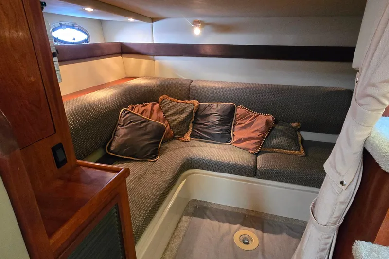 Slide: The Image of 2005 Cruisers Yachts 340 Express cabin interior with cozy seating and decorative pillows. - 21